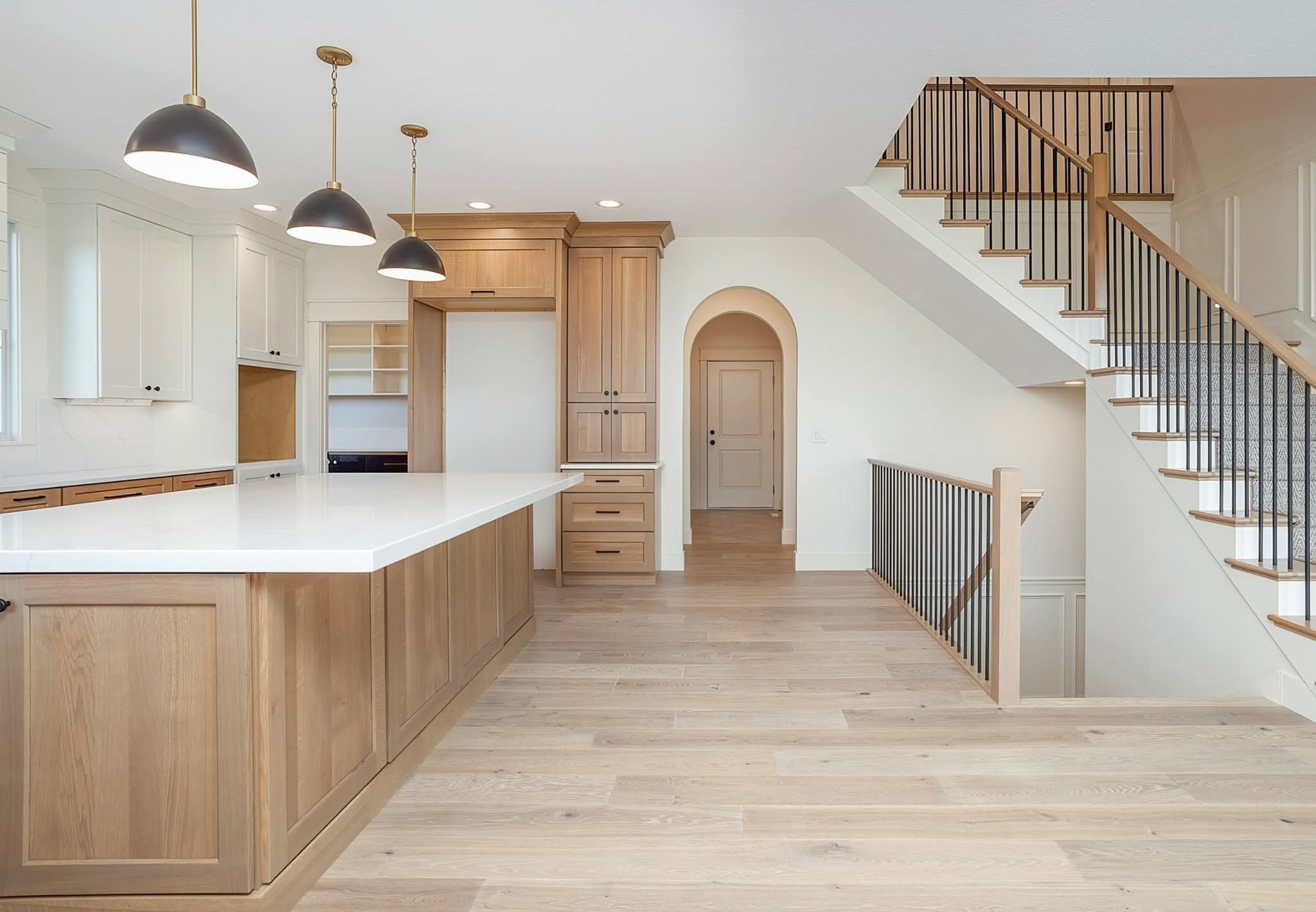 Kitchen renovation near Cherry Hills Village — dark cabinetry and custom staircase by PrestigeCore
